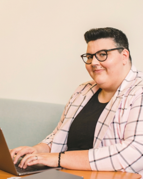 Practitioner smiling while working on a laptop